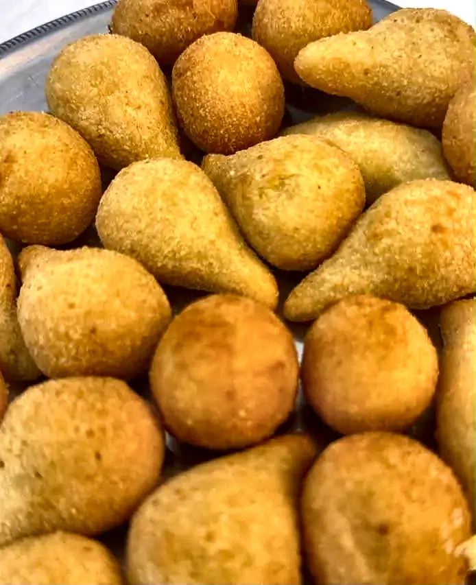 Coxinhas douradas recém-fritas servidas na festa